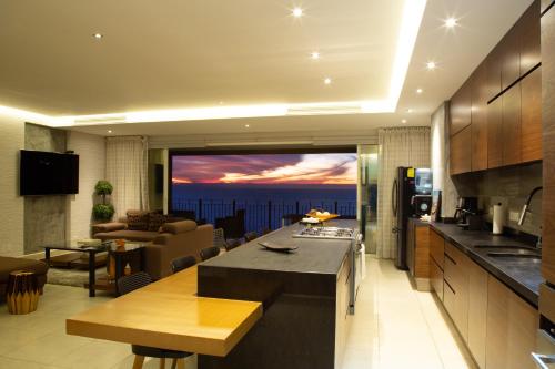 a kitchen and living room with a view of the ocean at Gorgeous 15 Floor Grand Venetian in Puerto Vallarta