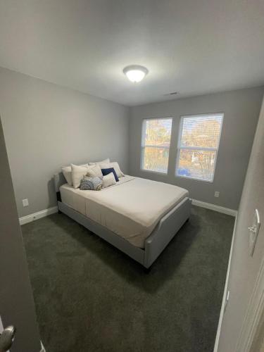 a bedroom with a bed in a room with two windows at Bloom’s Retreat in Norfolk