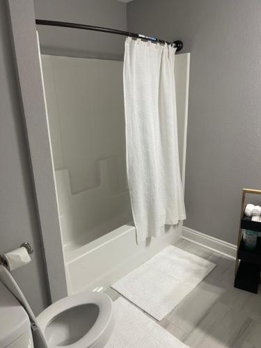 a bathroom with a toilet and a shower curtain at Bloom’s Retreat in Norfolk