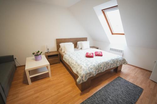a bedroom with a bed with two red shoes on it at Pension Štěpán in Mikulov