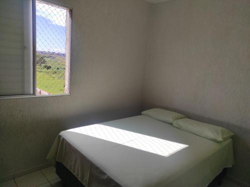 Bett in einem Zimmer mit Fenster in der Unterkunft Apartamento inteiro no Alto Umuarama, próximo ao Aeroporto, Medicina e Granja Marileusa. in Uberlândia