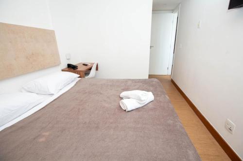 a bedroom with a bed with two towels on it at Rede Andrade Express in Salvador