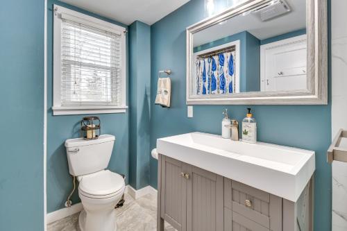 ein Badezimmer mit einem weißen Waschbecken und einem Spiegel in der Unterkunft Tranquil Auburn Lakehouse with Sunroom and Game Room! in Auburn