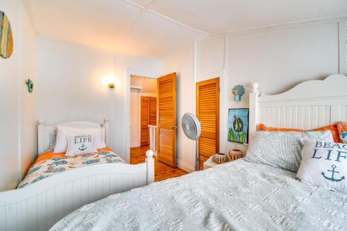 ein weißes Schlafzimmer mit einem Bett und einem Spiegel in der Unterkunft Tranquil Auburn Lakehouse with Sunroom and Game Room! in Auburn