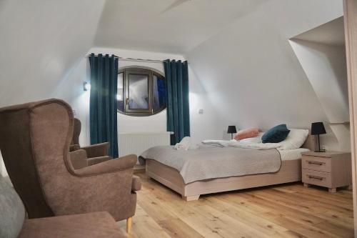 ein Schlafzimmer mit einem Bett mit blauen Vorhängen und einem Stuhl in der Unterkunft Rajchertówka in Kazimierz Dolny