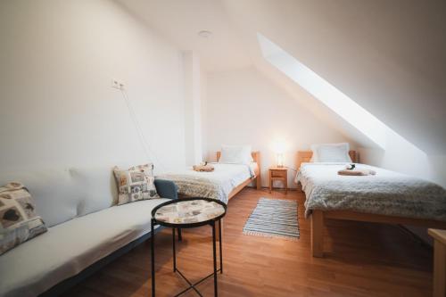 a attic room with two beds and a table at Pension Štěpán in Mikulov
