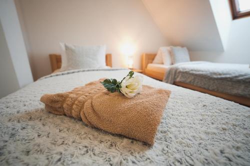 a bed with a towel with a flower on it at Pension Štěpán in Mikulov