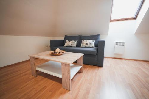 a living room with a blue couch and a table at Pension Štěpán in Mikulov