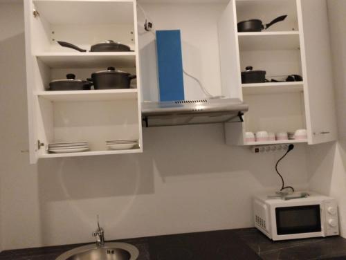 cocina con armarios blancos y microondas en Evido Apartments en Salzburgo