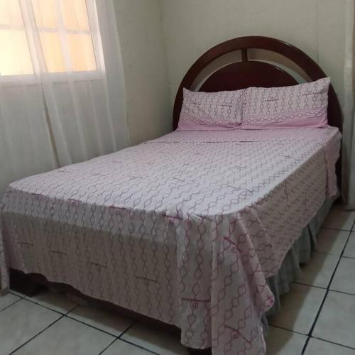 a bedroom with a bed with a pink bedspread at amplia y cómoda casa 
