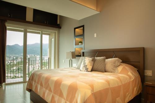 a bedroom with a bed with a view of a city at Gorgeous 15 Floor Grand Venetian in Puerto Vallarta