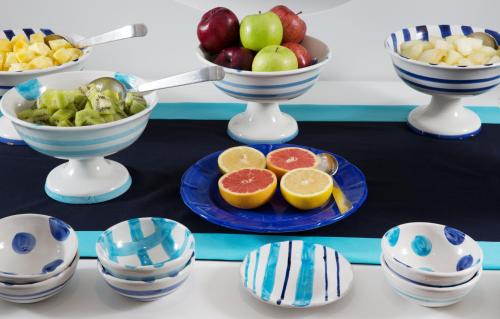 a table topped with blue and white bowls of fruit at Capo la Gala Hotel&Wellness in Vico Equense