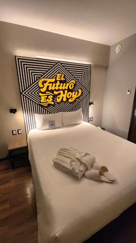 a bedroom with a white bed with a sign on it at ibis styles Lima San Isidro in Lima