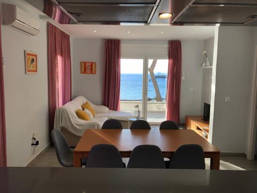 un soggiorno con tavolo e vista sull'oceano di Veuràs el Mar - Almadrava Beach House a Roses