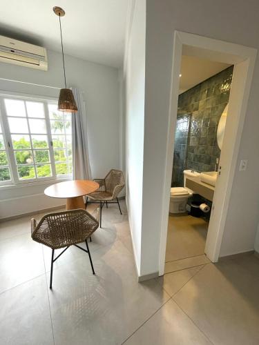 a room with a table and chairs and a bathroom at Hotel Pousada 7 Mares in Itapema