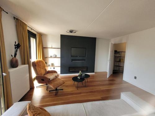 een woonkamer met een stoel en een televisie bij Alex Place in Utrecht