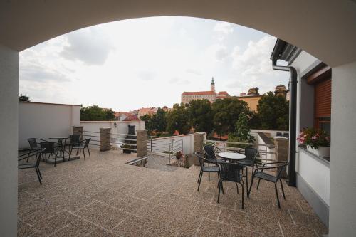 a balcony with tables and chairs and a view of a city at Pension Štěpán in Mikulov