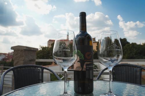 a bottle of wine sitting on a table with two glasses at Pension Štěpán in Mikulov