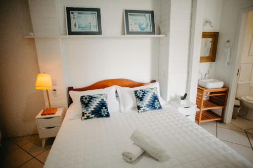a bedroom with a large white bed with pillows at Hotel Pousada 7 Mares in Itapema