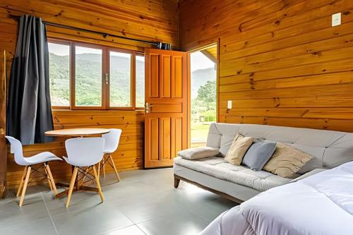 a bedroom with a couch and a table in a room at Cabanas aconchegantes. Desfrute da natureza e praia in Florianópolis