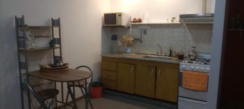 cocina con fogones, fregadero y mesa en Departamento MDP (Para 4 personas Maximo) en Mar del Plata