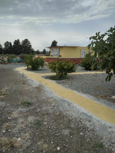 a yellow house with a yellow road in a yard at MERSINERA Paradise Garden NOAH HOUSE in Kivisil