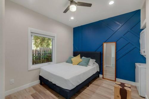 a bedroom with a blue accent wall and a bed at Stylish guest house near colleges in Claremont