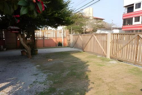 a wooden fence with a tree in a yard at Pouso do Guarani - 200m do mar|wifi|Ar cond in Florianópolis