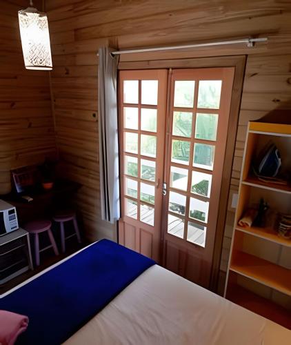 a bedroom with a bed and a window at Pouso do Guarani - 200m do mar|wifi|Ar cond in Florianópolis