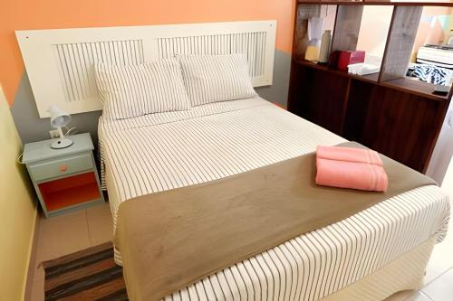 a bedroom with a bed with a pink bag on it at Pouso do Guarani - 200m do mar|wifi|Ar cond in Florianópolis