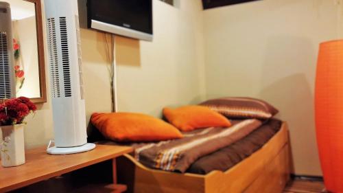 a room with a bed with orange pillows on it at B&B Bazeni in Sarajevo