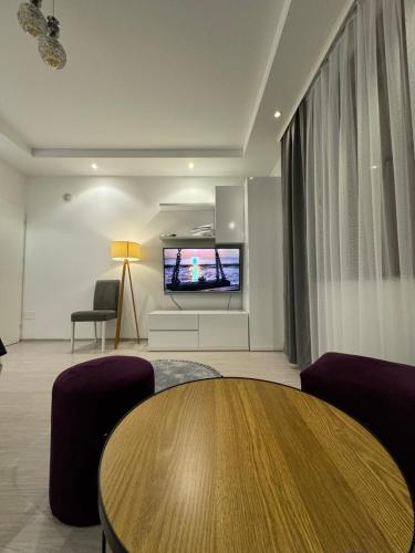 a living room with a table and a flat screen tv at Zani Boutique Hotel in Prizren