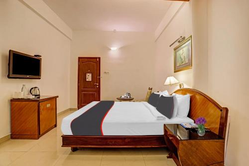 a hotel room with a bed and a television at Hotel Indraprastha in Trivandrum