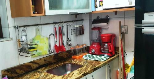 a kitchen counter with a sink and utensils on the wall at Copacabana- Beach 2 Rooms in Rio de Janeiro