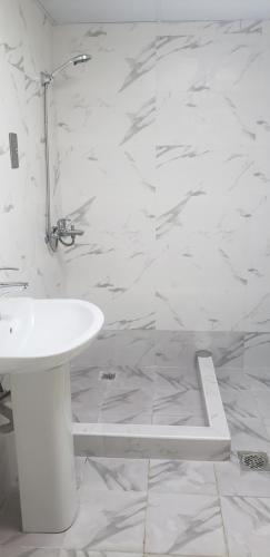 een witte badkamer met een wastafel en een douche bij Blessed Rest house in Dubai
