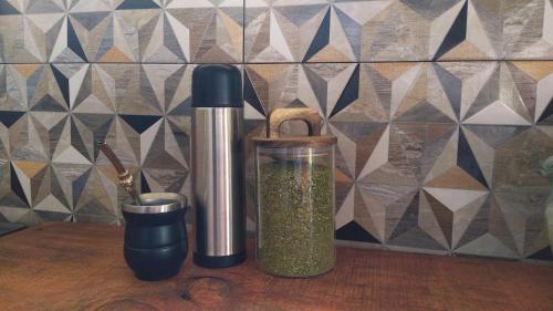 a counter with a container of spices and a knife at Glass in Punta Del Diablo