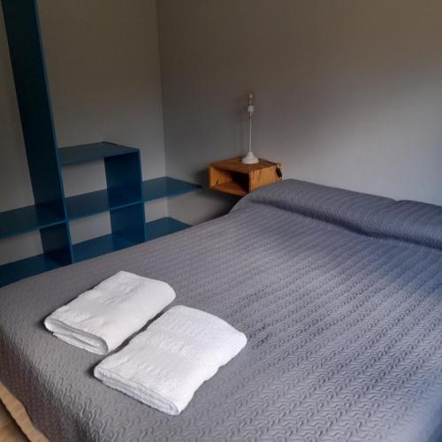 Un dormitorio con una cama con dos toallas encima. en Eskel III, en Esquel