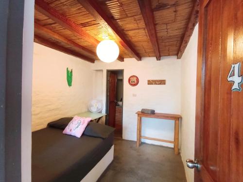 1 dormitorio con cama, mesa y puerta en Casa Naranja, en Máncora