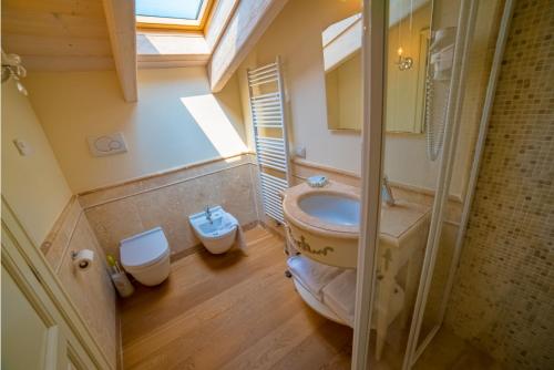 łazienka z umywalką, toaletą i oknem w obiekcie Garda Residence San Vigilio Golf w mieście Pozzolengo