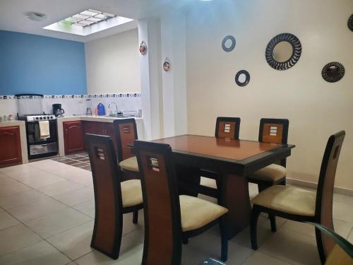 een keuken en eetkamer met een tafel en stoelen bij Departamento Don Tuquito in Loja