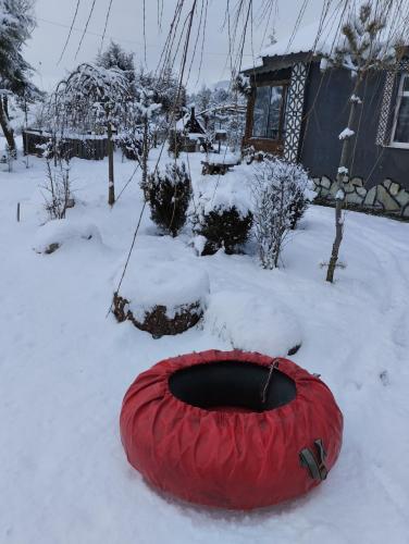 a red tire in the snow next to a house at İpekyolu dağ evleri in Mudurnu