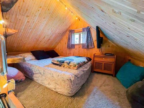 a bedroom with two beds in a wooden cabin at Glamping Villa del Bosque in Santa Rosa de Cabal