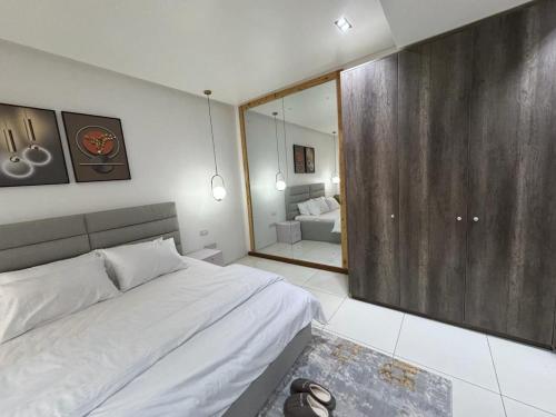 ein Schlafzimmer mit einem großen Bett und einem großen Spiegel in der Unterkunft Zara 2 in Lekki