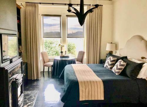 a bedroom with a bed and a table and windows at Pacific Heights Chic Jr Studio in San Francisco