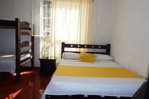 a bedroom with a bed with a yellow pillow on it at Torre del Sol in Villavicencio