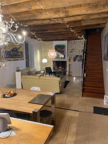 - un salon avec un canapé, une table et une cheminée dans l'établissement Maison familiale avec piscine, à Saint-Amand-Montrond