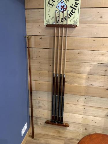 une horloge sur un mur à côté d'un mur en bois dans l'établissement Maison familiale avec piscine, à Saint-Amand-Montrond