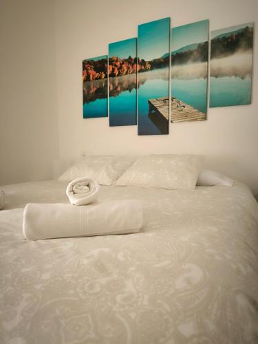 un lit avec un bouquet de peintures sur le mur dans l'établissement La casita de Lyra, à Grenade