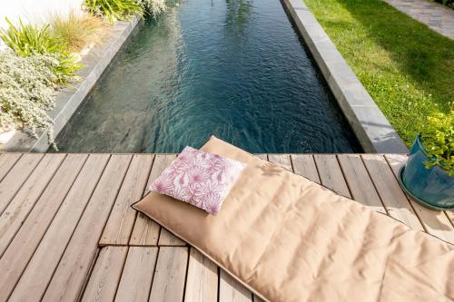 um banco num deque de madeira junto a uma piscina em Splendid townhouse with private pool em Le Bouscat