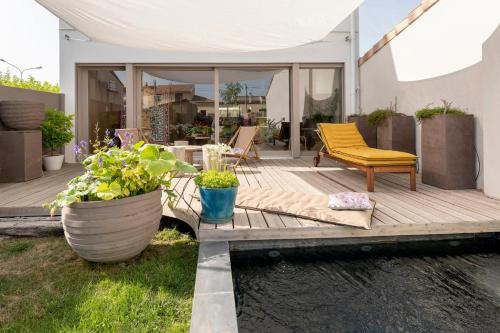 una terraza de madera con una silla amarilla y un poco de agua en Splendid townhouse with private pool en Le Bouscat
